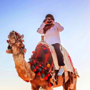 woman-in-white-dress-sitting-on-a-camel