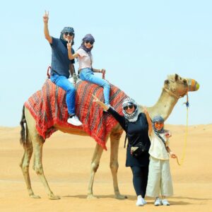 two-people-sitting-on-a-camel-in-desert.